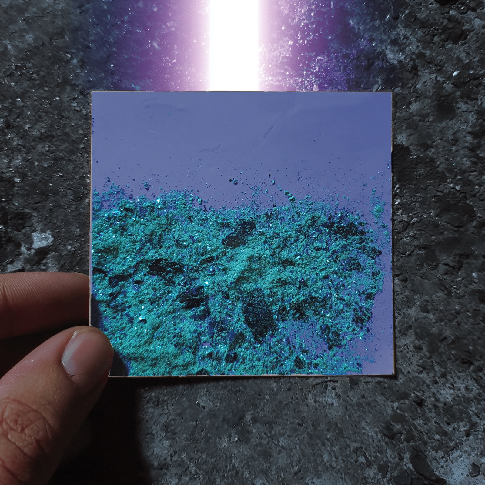 Hand holding a glowing material sample card